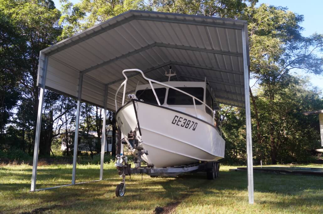 A boat parked underneath a shade shelter