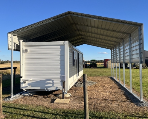 a white trailer under a shade shed