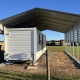 a white trailer under a shade shed