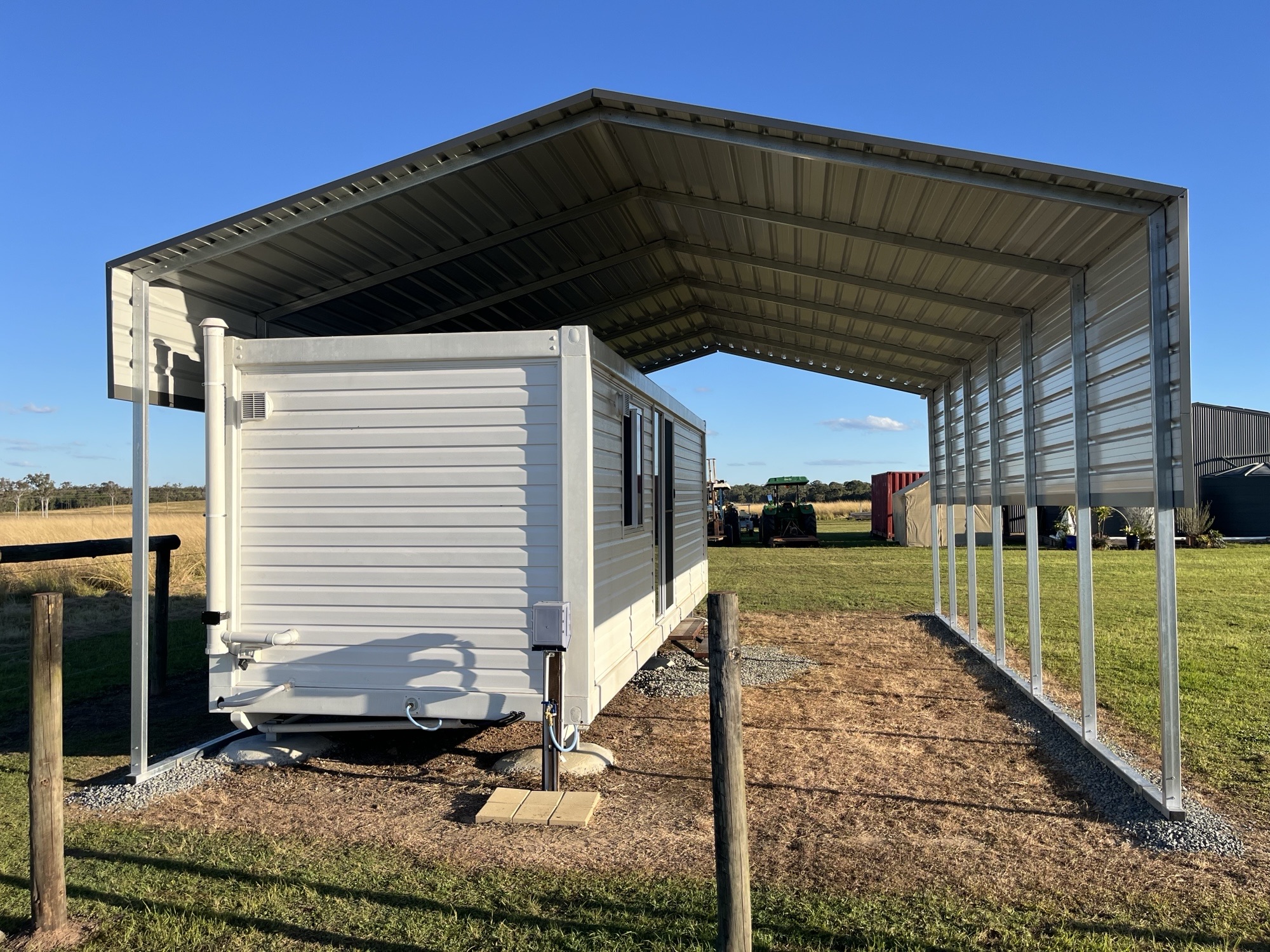 a white trailer under a shade shed