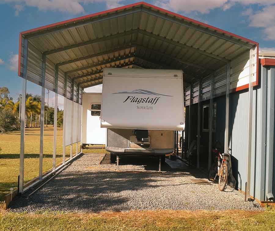 Metal carport with trailer underneath