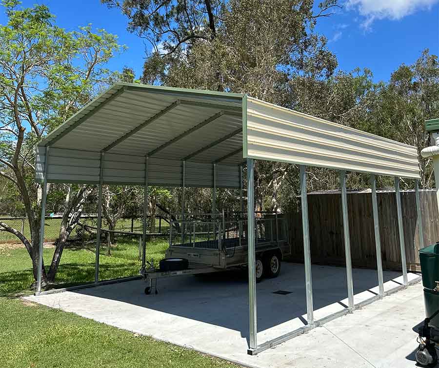 Metal carport with trailer underneath